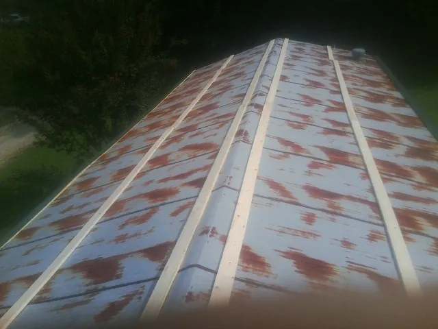 Rusted metal roof panels with new wood purlins before replacement — Storm Damage Roof Repair in Carlisle by Roofing Brothers