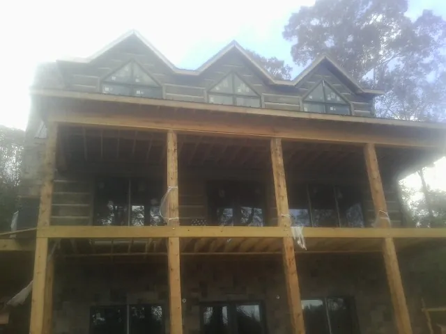 Dormers and porch framing on a large log home under construction — Roof Coating work by our crew in Carlisle